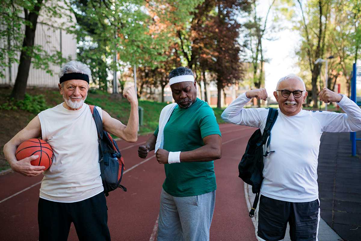 Three elderly men posing in funny positions on their way to play a basketball game