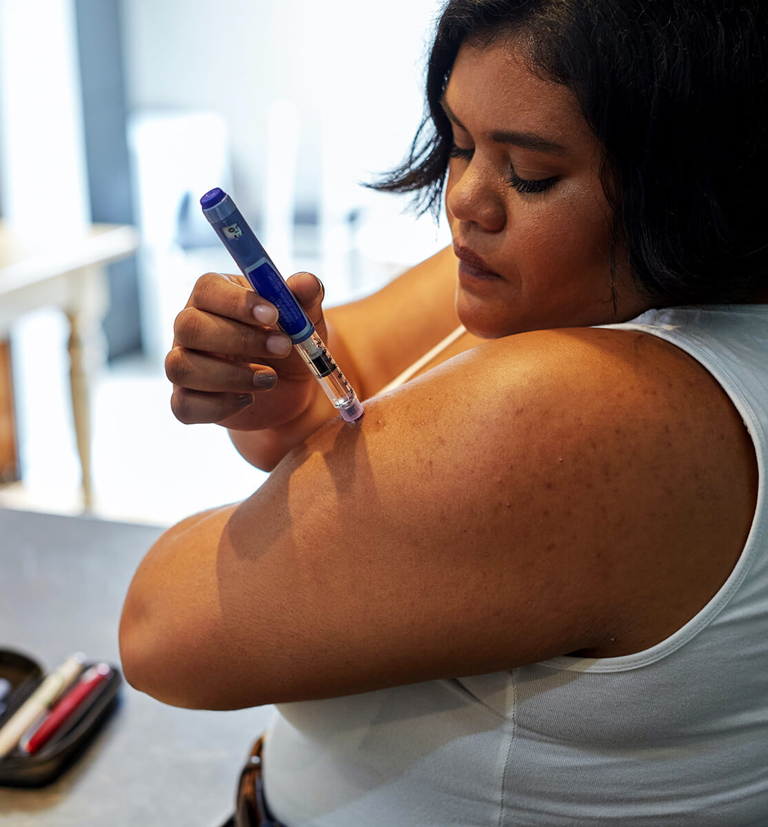 Overweight woman injecting herself with an insulin pen