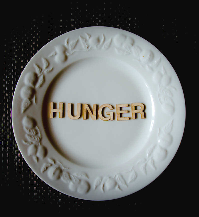 Plate with wooden letters spelling out the word "Hunger"