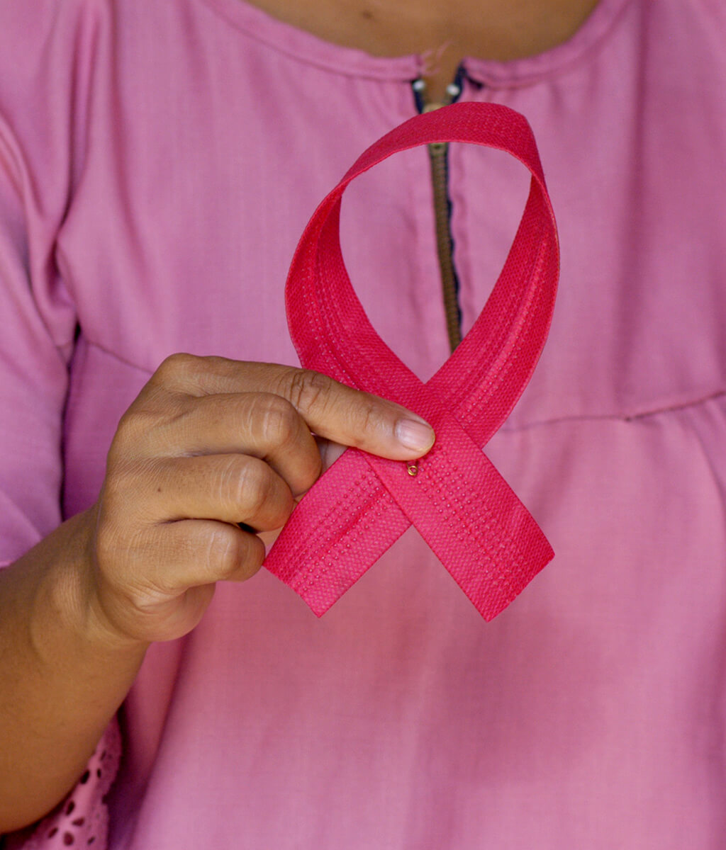 Woman holding up a pink breast cancer ribbon