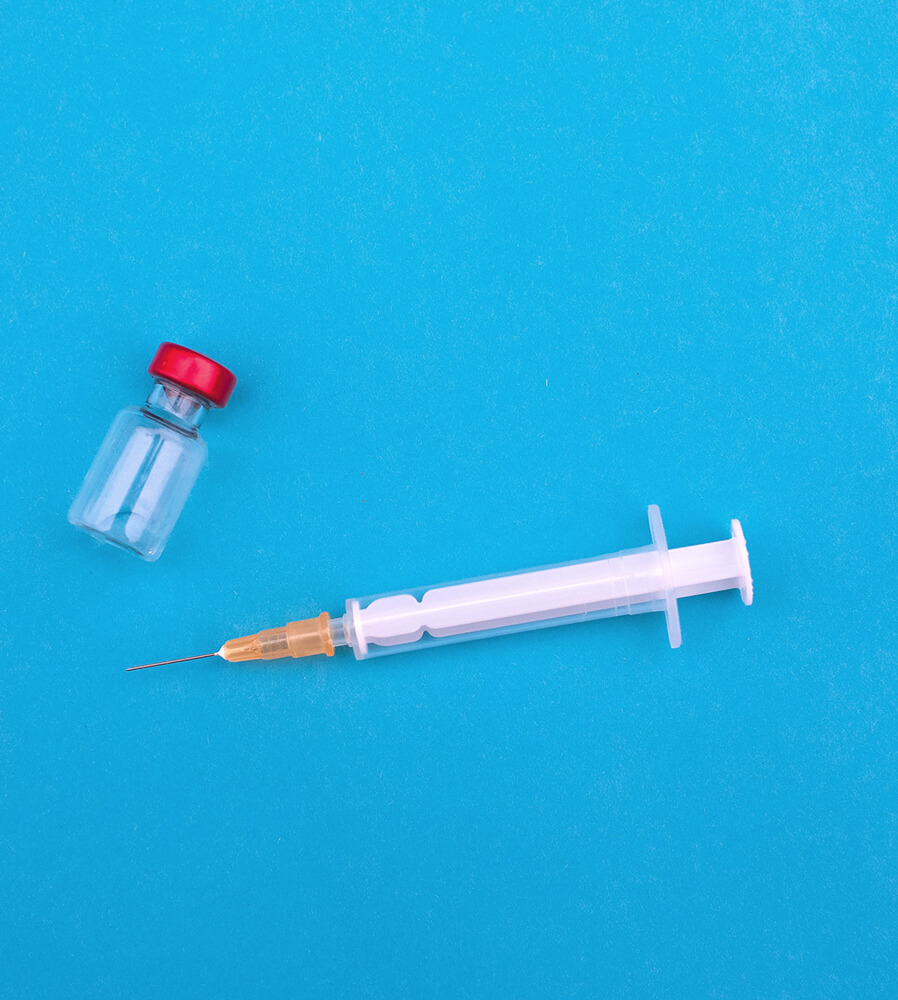 Medical needle and medication vial on a table